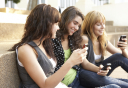 Group Of Teenage Students Sitting Outside On College Steps Using Mobile Phone Group Of Teenage Students Sitting Outside On College Steps Using Mobile Phone